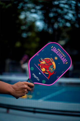 A close up of a hand holding the smashkari paddle in action on a pickleball court