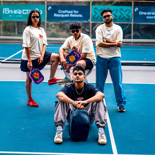 4 people wearing Sprentzo Smashkari merch and holding pickleball paddles on a pickleball court