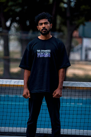 Man standing on a pickleball court wearing the sprentzo chronicles of pinaka t-shirt - front view