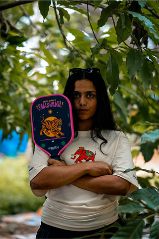 Woman holding Pickleball paddle with a tiger design outdoors